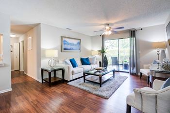 A living room with a white couch and a painting on the wall